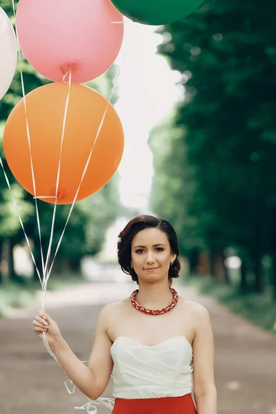 Брюнетка с цветными воздушными шарами — стоковое фото