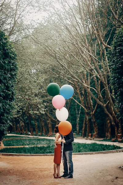 Paar zoenen zich te verschuilen achter ballonnen — Stockfoto