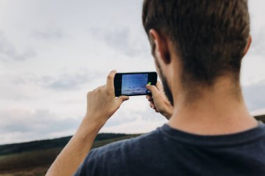 telefon ve çekici fotoğraf tutan adam