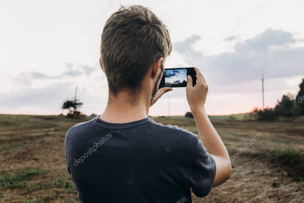 man holding phone and taking photo