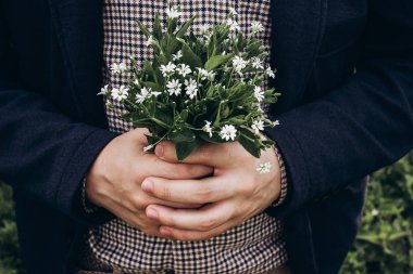 adam holding kır çiçekleri buketi