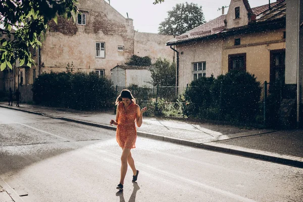 Женщина бежит по дождливой улице — стоковое фото