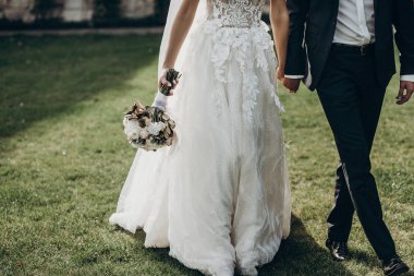 Düğün çifti el ele tutuşuyor.