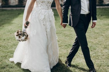 Düğün çifti el ele tutuşuyor.