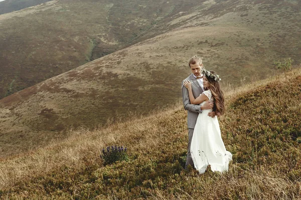 Recién casados abrazándose en las montañas —  Fotos de Stock