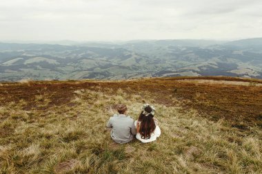 Gelin ve damat çimlerde oturan