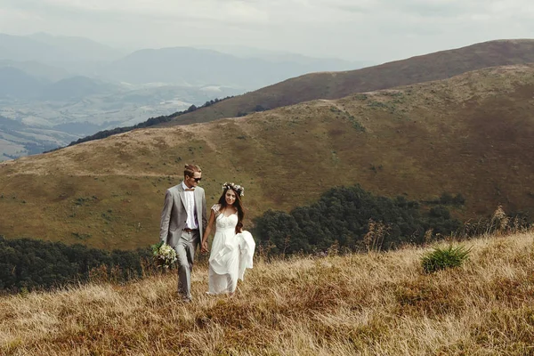Пара тримає руки, ходячи в горах — стокове фото