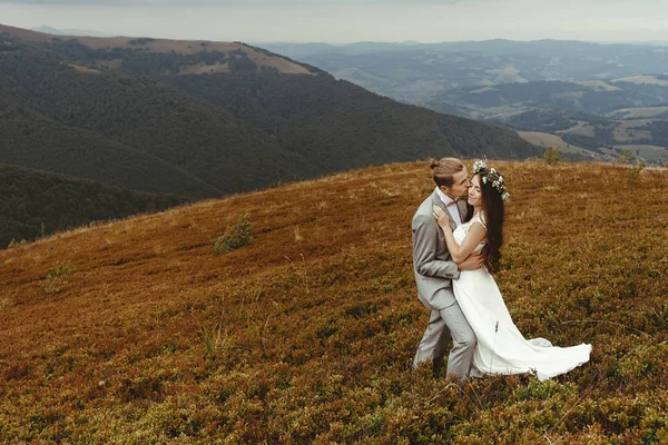 Recién casados abrazándose en las montañas —  Fotos de Stock