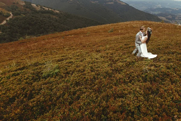 Bride and groom dancing in mountains — Stock Photo, Image