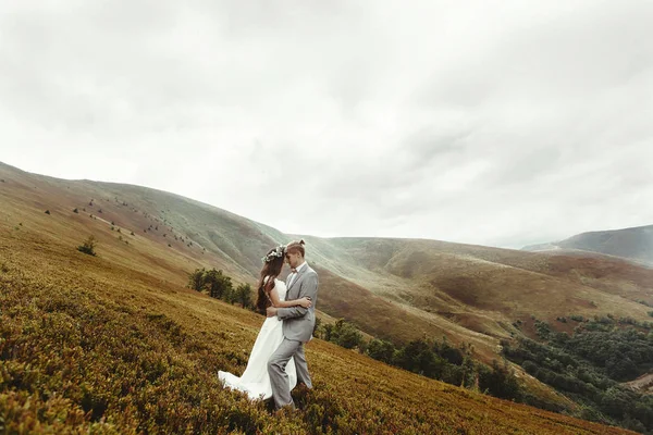 Boho recién casados abrazándose en las montañas —  Fotos de Stock