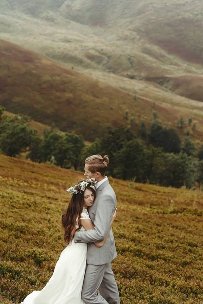 Boho recién casados abrazándose en las montañas —  Fotos de Stock