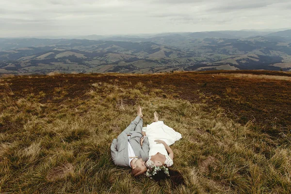 Nevěsta a ženich ležící na trávě — Stock fotografie