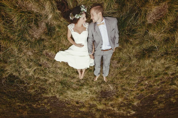 Recém-casados deitado na grama — Fotografia de Stock