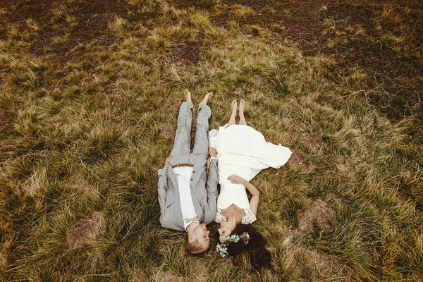 Молодожены лежат на траве — стоковое фото