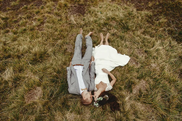 Recém-casados deitado na grama — Fotografia de Stock
