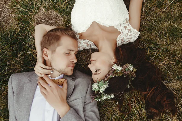 Recién casados acostados en la hierba — Foto de Stock