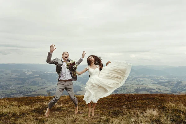 Recién casados saltando en las montañas —  Fotos de Stock