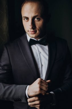 Takım elbiseli damat papyonlu.