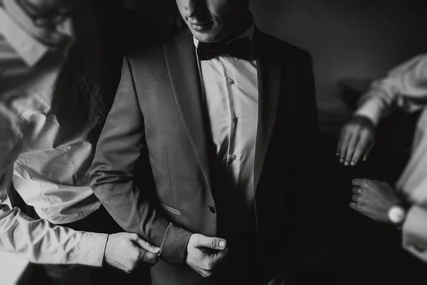 Groomsmen helping groom getting ready — Stock Photo, Image