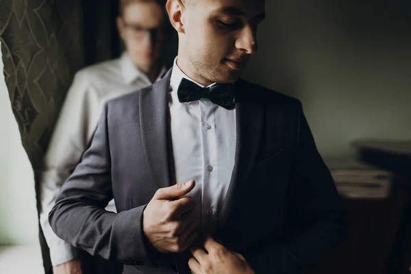 Groomsmen βοηθώντας το γαμπρό να πάρει έτοιμο — Φωτογραφία Αρχείου