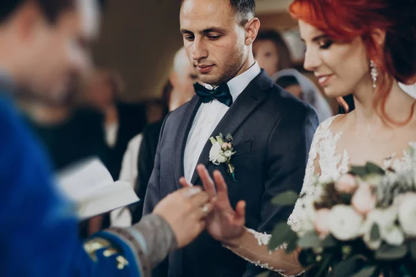 Casal colocando em alianças de casamento — Fotografia de Stock