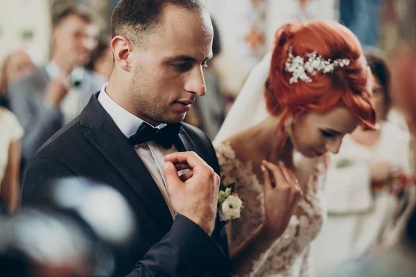 Bruid en bruidegom kussen kronen — Stockfoto
