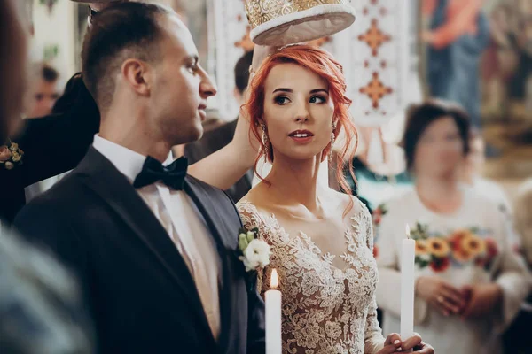 Noiva e noivo sob coroas na igreja — Fotografia de Stock