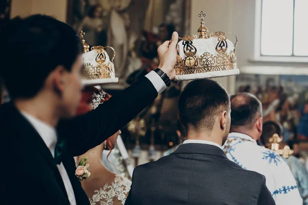 Sposa e sposo sotto corone in chiesa — Foto Stock