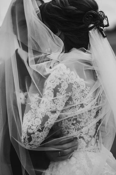 Nygifta kramas nära retro bil — Stockfoto