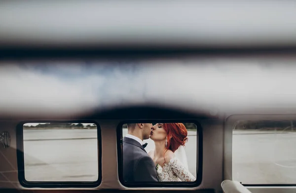 Recém-casados abraçando e beijando — Fotografia de Stock