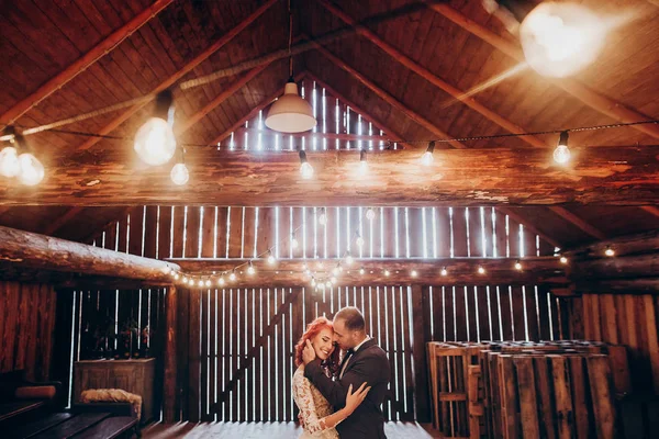 Newlyweds hugging under retro lights — Stock Photo, Image