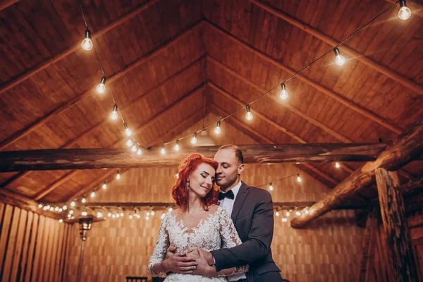 Newlyweds knuffelen onder retro lampen — Stockfoto