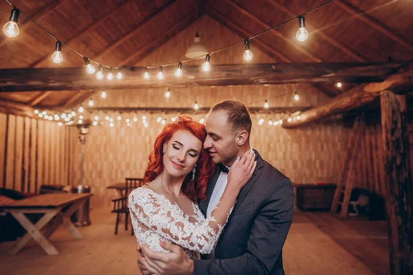 Newlyweds knuffelen onder retro lampen — Stockfoto