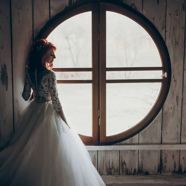 bride posing at round window