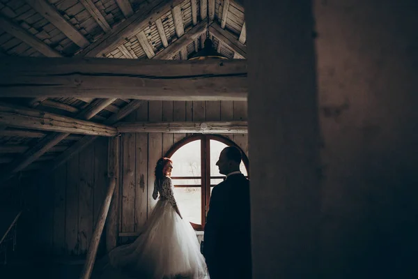 Novio y novia posando cerca de la ventana — Foto de Stock