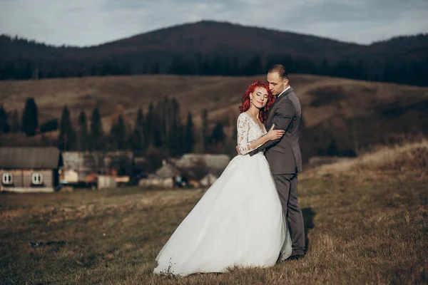 Noiva e noivo posando nas montanhas — Fotografia de Stock