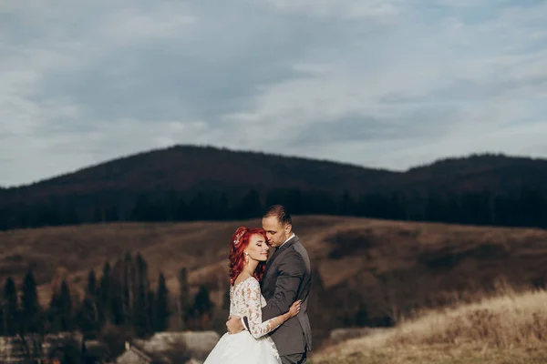 Noiva e noivo posando nas montanhas — Fotografia de Stock