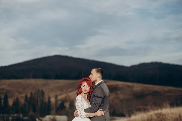 Noiva e noivo posando nas montanhas — Fotografia de Stock