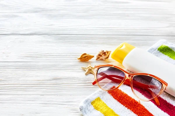 Toalha, óculos de sol, protetor solar amarelo — Fotografia de Stock