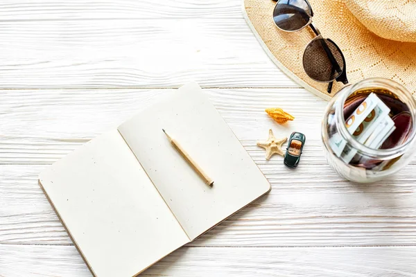 Σημειωματάριο με μολύβι, χρήματα, γυαλιά ηλίου και το καπέλο — Φωτογραφία Αρχείου
