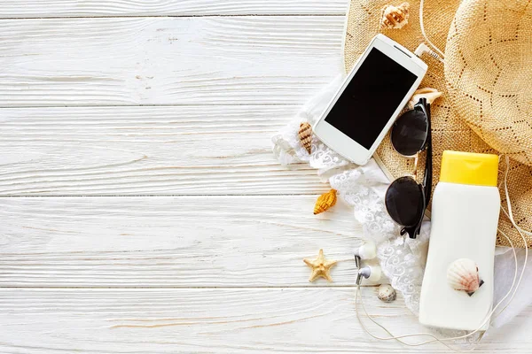 Telefoon, zonnebrandcrème, zonnebril en hoed — Stockfoto