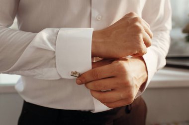 üzerinde altın kol düğmesi koyarak damat