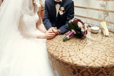 Gelin ve damat el ele tutuşuyorlar.