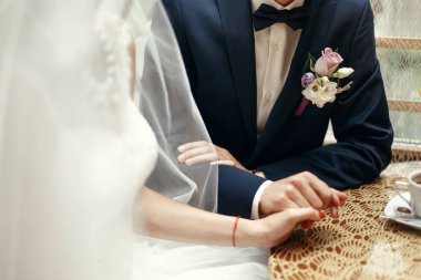 Düğün çifti el ele tutuşuyor.