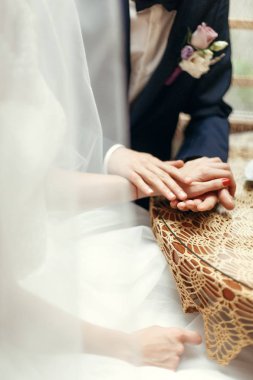 Düğün çifti el ele tutuşuyor.