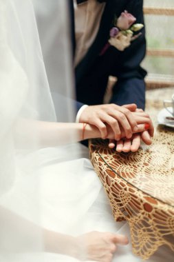 Düğün çifti el ele tutuşuyor.