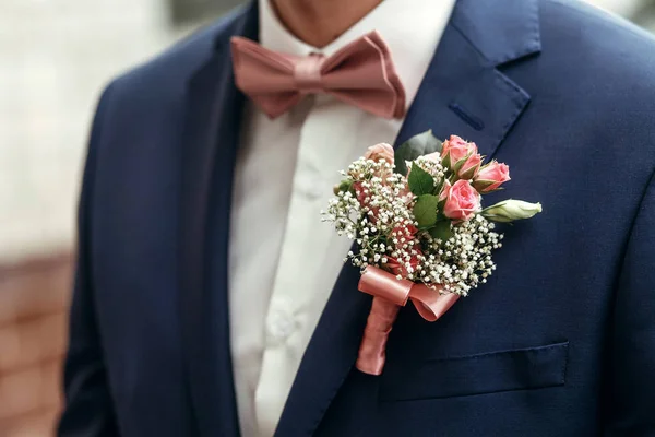 Stijlvolle bruidegom met roze rozen — Stockfoto