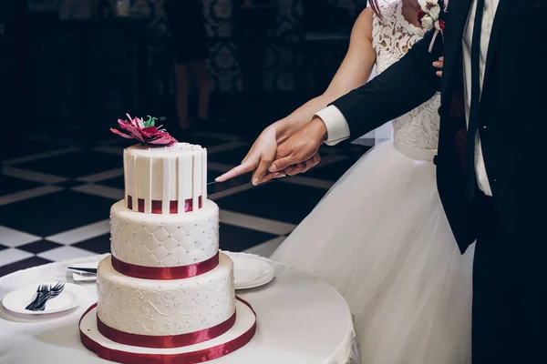 Bruid en bruidegom snijden taart — Stockfoto