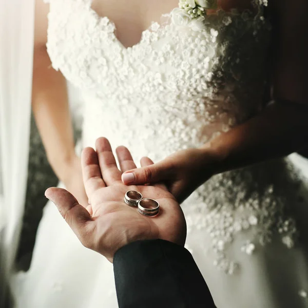 Casal segurando anéis de casamento — Fotografia de Stock