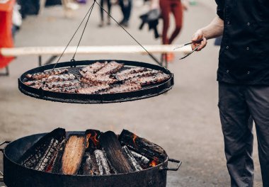 ızgara et. adam holding çelik dilleri ve kavurma et domuz o